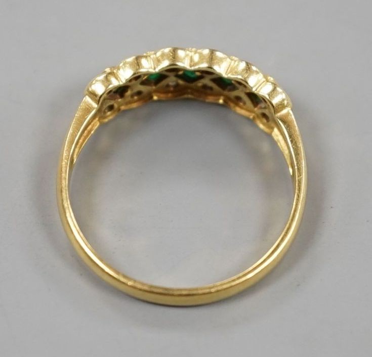 A modern 18ct gold, emerald and diamond line cluster set half hoop ring, size R, gross 3.9 grams.